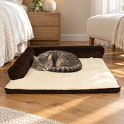 Tabby cat resting on coffee corduroy bed in a softly lit bedroom